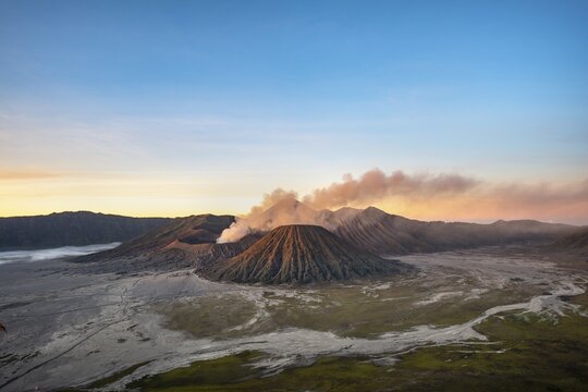 Volcanic landscape at sunrise, smoking volcano Gunung Bromo, with Mt. Batok, Mt. Kursi, Mt. Gunung Semeru, Bromo-Tengger-Semeru National Park, Java, Indonesia