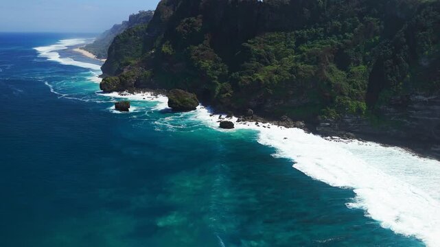 Scenic landscape with rocky cliff coastline and blue ocean with waves. Drone view
