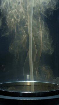Vertical video: Rising golden vapor column from base in clear cylinder, forming plumes for demo