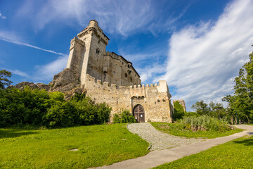 Historic castle in Austria surrounded by picturesque countryside and lush alpine scenery, presenting a timeless European architectural landmark beneath a dramatic sky. The elegant fortress © Yuliia