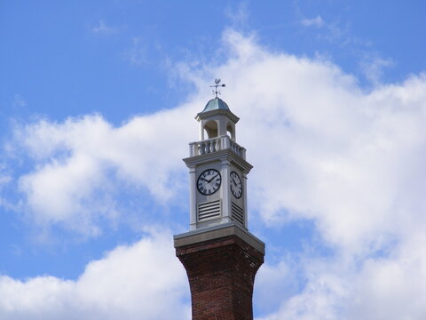 Classic Brick Clock Tower Under Blue Sky with White Clouds