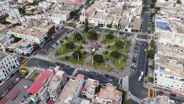 Aerial view of the historic Plaza Matriz de Callao with its central gazebo, lush palm trees, and surrounding urban architecture in Callao, Callao Region, Peru.
