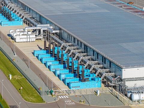 Aerial view of the Google Data Center Middenmeer featuring rows of blue industrial cooling units and extensive rooftop infrastructure in Middenmeer, North Holland, Netherlands.