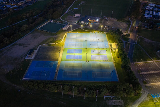 Aerial view of Gordon Spratt Reserve with illuminated tennis courts at night in Tauranga, Bay of Plenty Region, New Zealand.