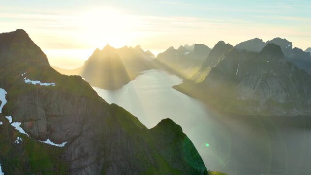 Aerial shot of the ocean meeting the mountains along the beautiful coast of Northern Norway near the town of Reine