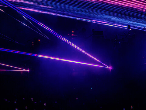 Purple and Blue Laser Beams Crossing a Dark Event Space
