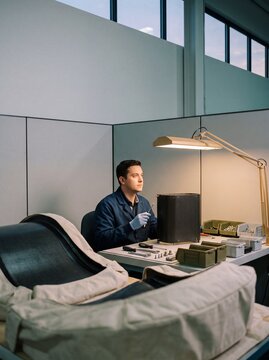 Focused male engineer assembling high tech carbon fiber components at a modern industrial workstation