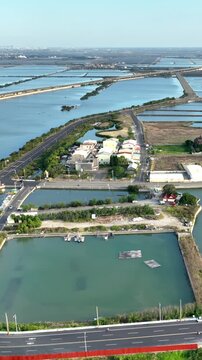 Vertical aerial shot of large fish ponds along the coast of Taiwan used for farming fish and shrimp.