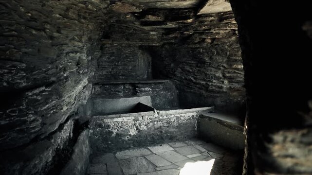 Ancient stone crypt interior with carved recesses and dim lighting