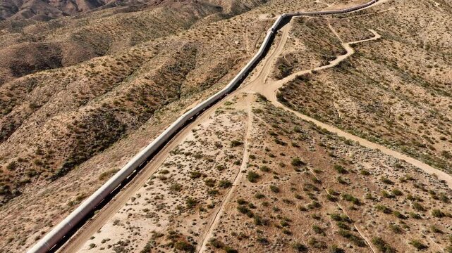 Aerial shot of the Los Angeles Aqueduct as it passes over some low mountains in California. The aqueduct supplies water to Los Angeles and Southern California.