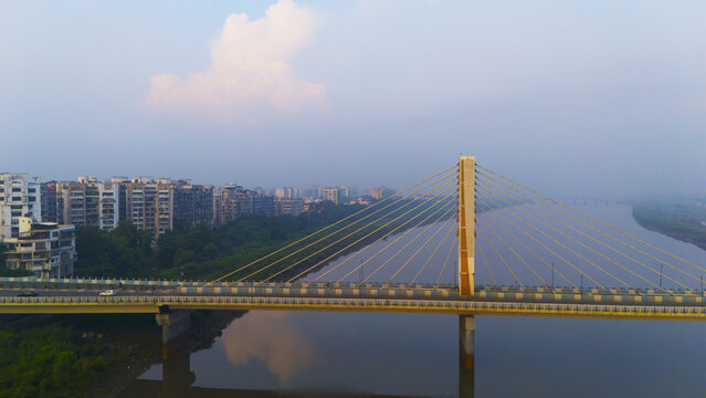 Aerial view of the cable-stayed bridge spanning the Tapi River with urban buildings and a hazy sky in the background in Surat, Gujarat, India.