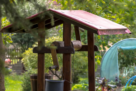 W ogrodzie znajduje się drewniana obudowa studni z czerwonym, spiczastym dachem. Wyposażona jest ona w korbę, łańcuch oraz wiszące  wiadro. Studnię otacza bujna zieleń co wskazuje na p&oacute;źnoletnią porę 