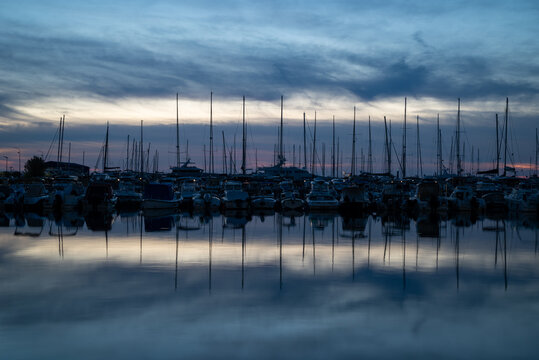 Marina at Dusk with Sailboats and Reflections