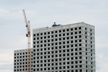 Fototapeta premium multi‑storey panel building under construction and construction crane