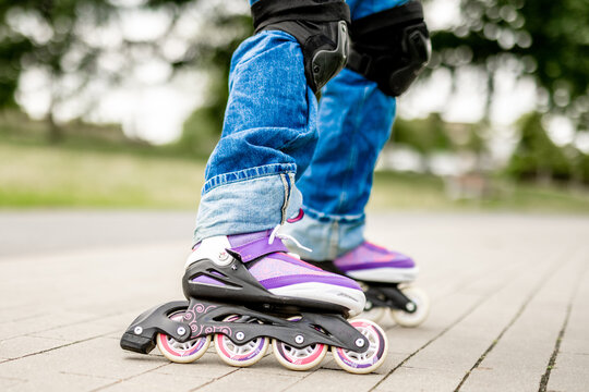 Child inline skating on park path wearing safety gear