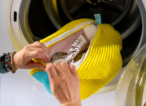 Washing pink sneakers inside laundry bag