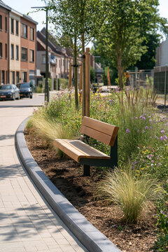 Green public space with benches and mature trees in a modern residential neighborhood. landscaped urban residential environment with pedestrian paths, wooden benches, mature street trees, flowering ve