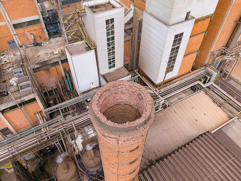 Aerial view of an industrial facility featuring a prominent brick chimney, complex pipe networks, and industrial buildings in Araras, Sao Paulo, Brazil.
