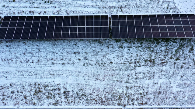Aerial view of solar panels installed in a snow-covered field in Latvia.