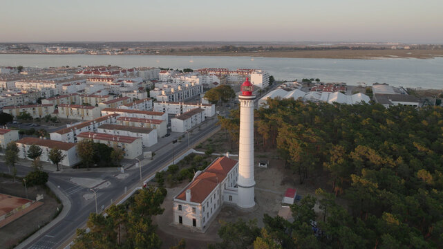 Aerial view of the Vila Real de Santo Antonio Lighthouse with its red lantern, surrounded by pine trees in Vila Real de Santo Antonio, Faro District, Portugal.