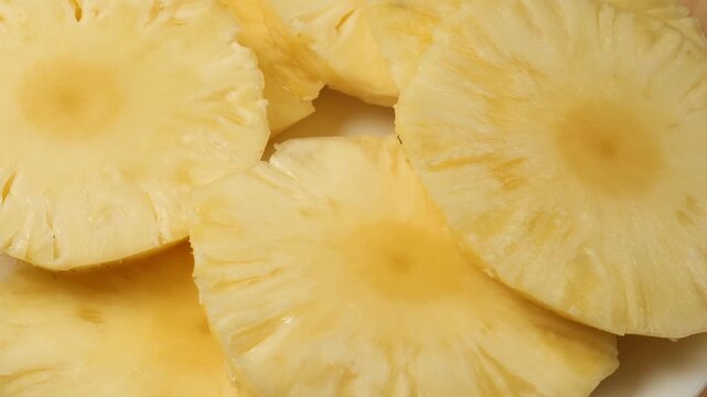 Fresh juicy sliced pineapple rings rotating
