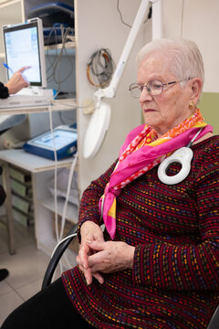 Elderly woman with a medical device receiving a pacemaker checkup at cardiology hospital