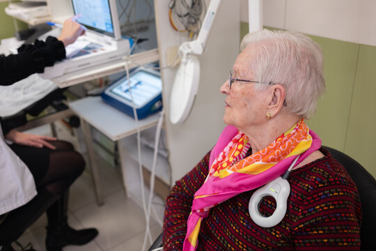 Doctor checking a pacemaker device on an elderly patient's chest during a medical examination at hospital