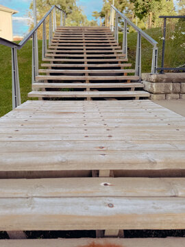 Escalier en bois dans le parc avec des rampes en m&eacute;tal. 
Gros plan sur des marches en bois.	
