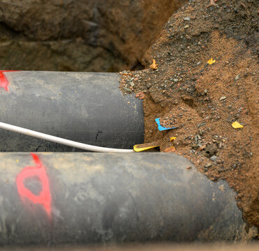 Large underground utility pipes exposed during urban excavation work.