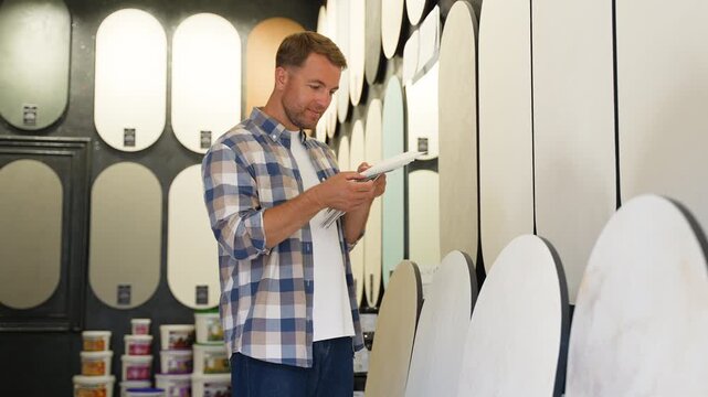 Designer choosing paint color sample in hardware store