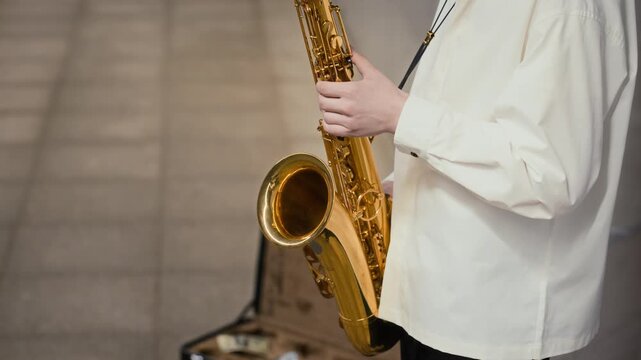 Caucasian young man playing saxophone in urban underpass with tilt up shot. Ideal footage for music education campaigns, artistic talent showcases, and jazz entertainment marketing