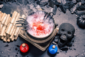 Fototapeta premium A dark skull rests beside glass flasks.