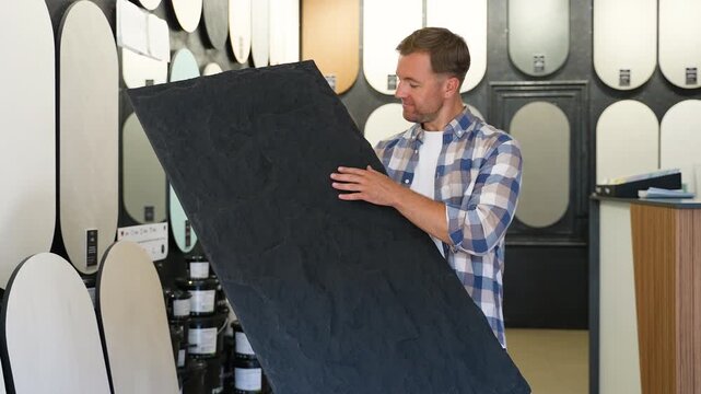 Man choosing stone veneer panel in a home improvement store