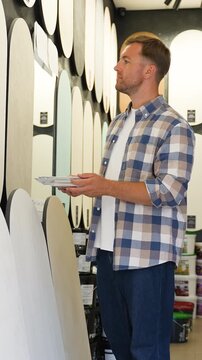 Man choosing paint color samples in hardware store