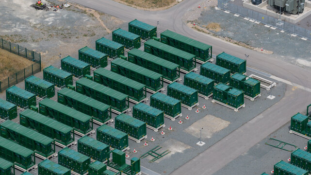 Aerial view of Thurrock Flexible Generation Substation featuring rows of green battery storage containers on a paved industrial site in Tilbury, England, United Kingdom.