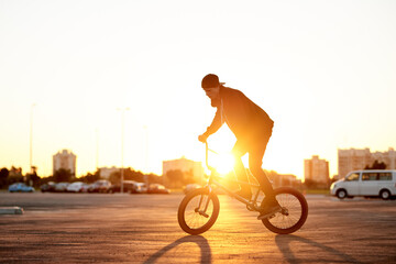 Naklejka premium BMX, flare and ride with man on bike in city for activity, adrenaline hobby or sports training. Exercise, balance and risk with extreme person on bicycle on street for action, cycling or energy
