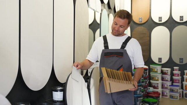 Professional painter choosing paint color swatch in a hardware store