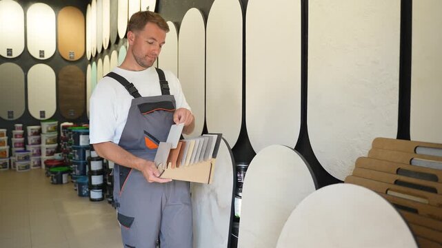 Male worker choosing decorative plaster in a hardware store