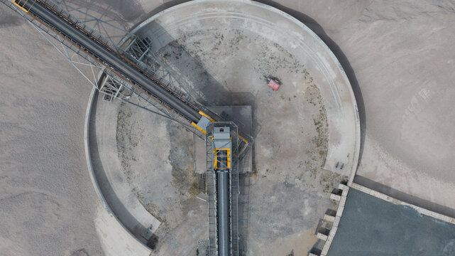 Aerial view of the Tarmac Tilbury industrial conveyor system with heavy machinery, gravel piles, and concrete structures in Tilbury, England, United Kingdom.