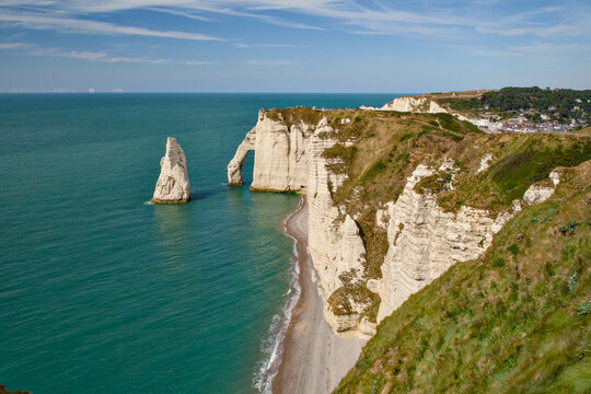 Etretat chalk cliffs and sea stacks above the pebble beach
