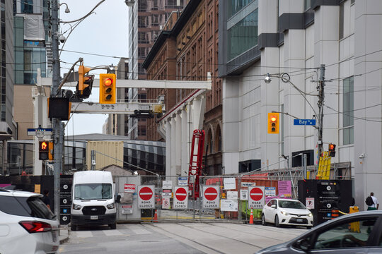 Ontario Line Queen Station construction site by Metrolinx with road closed signs and barriers at Toronto Bay Street, September 2026