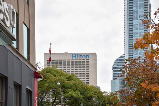 Hilton hotel building featuring prominent blue corporate signage situated among downtown Toronto skyscrapers, September 2026