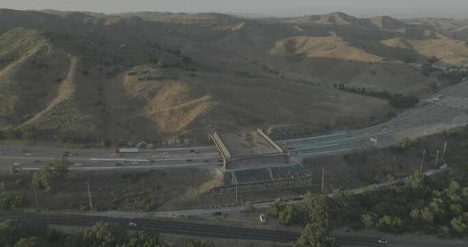 Hazy aerial view of freeway and overpass crossing in hill valley