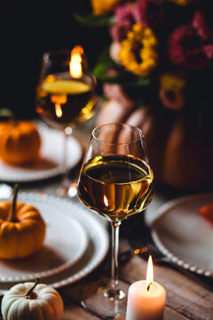 Beautiful elegant autumn table setting for thanksgiving family dinner or wedding with sunflowers. Orange pumpkin, floral centrepiece. Cozy fall home atmosphere. Wineglass, romantic marriage proposal