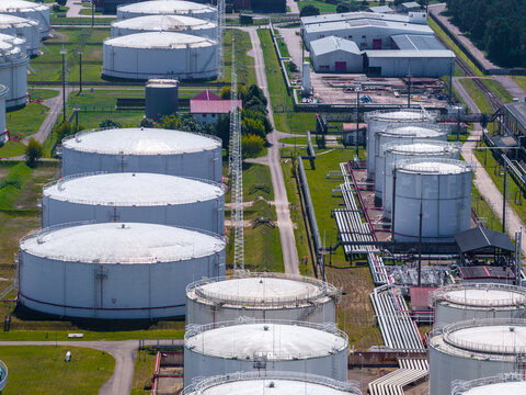 Aerial view of large white oil storage tanks and industrial pipelines at the Ventspils oil terminal in Ventspils, Latvia.