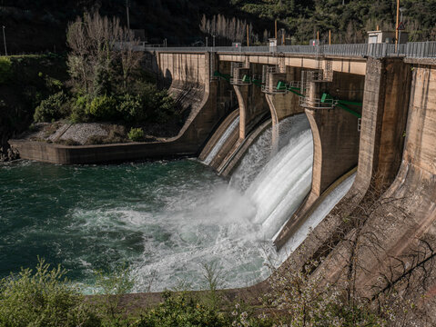 General view of the Penarrubia reservoir dam on the Sil River, where two floodgates are open, releasing a large flow of water, forming a white stream downwards
