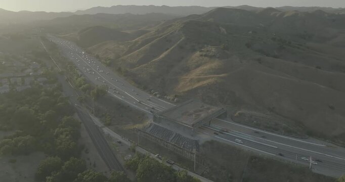 Hazy aerial view of freeway and overpass crossing in hill valley