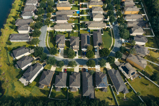 Aerial view of a planned residential community featuring rows of identical suburban houses with green lawns and paved streets in Jacksonville, Florida, United States.