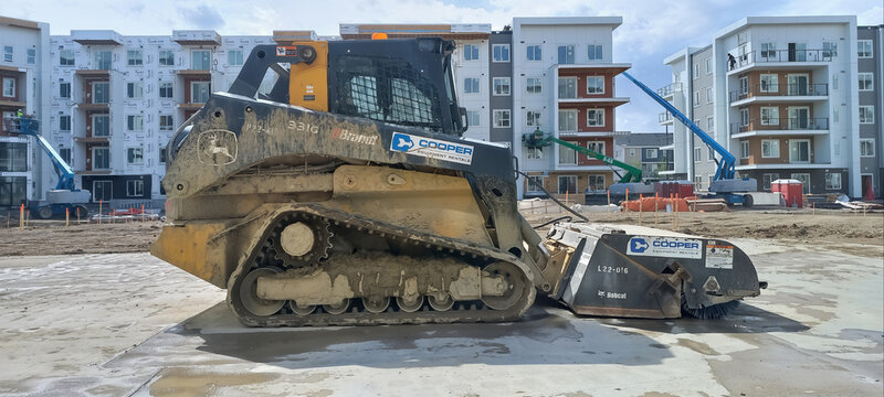 CALGARY, CANADA - 19 MAY 2026: John Deere 331G compact track loader with Bobcat sweeper attachment at construction site