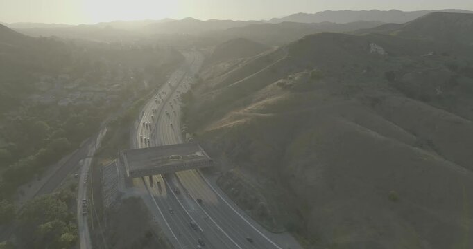 Hazy aerial view of freeway and overpass crossing in hill valley